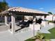 Covered patio with outdoor kitchen, seating area, and fire pit at 4530 W Misty Willow Ln, Glendale, AZ 85310