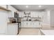 Well-lit kitchen with white cabinets, open shelving, and stainless steel appliances at 4602 N 47Th Ave, Phoenix, AZ 85031