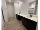 Modern bathroom with dual vanity, quartz countertop and wood look floors at 47250 W Mellen Ln, Maricopa, AZ 85139