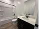 Well-appointed bathroom with a shower-tub combo, modern vanity, and wood-look tile flooring at 47250 W Mellen Ln, Maricopa, AZ 85139