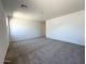 A spacious bedroom with neutral carpeting and bright lighting from a large window at 47250 W Mellen Ln, Maricopa, AZ 85139