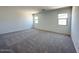 A spacious bedroom with large windows offering natural light and neutral carpeting at 47250 W Mellen Ln, Maricopa, AZ 85139