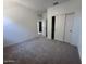 Neutral bedroom with plush carpeting, a closet with sliding doors, and an open doorway at 47250 W Mellen Ln, Maricopa, AZ 85139