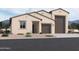 Tan two-story house with a large brown garage door and landscaping at 47250 W Mellen Ln, Maricopa, AZ 85139