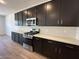 Featuring sleek dark wood cabinets, white countertops, and modern stainless steel appliances at 47250 W Mellen Ln, Maricopa, AZ 85139
