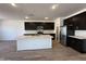 A kitchen with stainless steel appliances, a large island, dark wood cabinets, and wooden floors at 47250 W Mellen Ln, Maricopa, AZ 85139