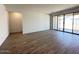 An expansive living room with modern floors and a sliding glass door to the outside at 47250 W Mellen Ln, Maricopa, AZ 85139