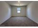 Spacious living area with plush carpeting, light paint, and a window for natural light at 47250 W Mellen Ln, Maricopa, AZ 85139