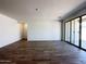 An expansive living room with modern floors and a sliding glass door to the outside at 47250 W Mellen Ln, Maricopa, AZ 85139