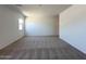 Bright living room features a large window and neutral carpet at 47250 W Mellen Ln, Maricopa, AZ 85139