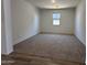 Spacious living area with plush carpeting, light paint, and a window for natural light at 47250 W Mellen Ln, Maricopa, AZ 85139