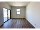 Bright living room with wooden floors, a sliding glass door, and natural lighting at 47250 W Mellen Ln, Maricopa, AZ 85139