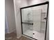 Tiled walk-in shower with a sleek black-framed glass door at 47250 W Mellen Ln, Maricopa, AZ 85139