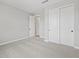 Bedroom featuring neutral carpet, a closet with sliding doors, and a door leading to an attached bathroom at 4816 N 177Th Ln, Goodyear, AZ 85395