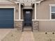 Close up of the front door, featuring a black front door and brick walkway and pillars at 4816 N 177Th Ln, Goodyear, AZ 85395