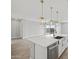 Bright kitchen features island with stainless steel sink, quartz countertops, and modern pendant lighting fixtures at 4816 N 177Th Ln, Goodyear, AZ 85395