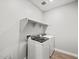 Well-equipped laundry room featuring modern washer and dryer, built-in shelving and tile floor at 4816 N 177Th Ln, Goodyear, AZ 85395