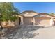 Beige house with two-car garage and landscaping at 5426 N Rattler Way, Litchfield Park, AZ 85340