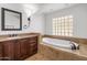 Relaxing bathroom with soaking tub, vanity, and glass block window at 7618 E Ironwood Dr, Scottsdale, AZ 85258