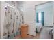 Clean bathroom with patterned shower curtain, tile surround, and wicker hamper at 10428 S 294Th Ave, Palo Verde, AZ 85343