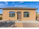 Front view of a small house with a brown door and arched windows at 12692 W Toltec Cir, Casa Grande, AZ 85194