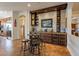 Open-concept bar area with stone accent wall, custom cabinets and beverage fridge at 1397 E Verde Blvd, Queen Creek, AZ 85140