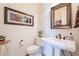 Powder room with pedestal sink, decorative mirror, and neutral color palette at 1397 E Verde Blvd, Queen Creek, AZ 85140