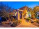 Home's front entrance featuring a charming walkway, desert landscaping, and a wrought iron gate at 1397 E Verde Blvd, Queen Creek, AZ 85140