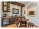 Rustic-style home bar with stone and wood features; wine storage and a game table at 1397 E Verde Blvd, Queen Creek, AZ 85140