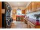 Spacious laundry room with stackable washer and dryer, and built-in cabinets at 1397 E Verde Blvd, Queen Creek, AZ 85140