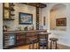 Elegant home wet bar with custom wood cabinets, stone backsplash, wine rack, and beverage cooler at 1397 E Verde Blvd, Queen Creek, AZ 85140