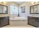 Bathroom with double vanity, soaking tub, and glass block window at 14113 W Windsor Ave, Goodyear, AZ 85395