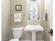 Small bathroom with pedestal sink and toilet at 14113 W Windsor Ave, Goodyear, AZ 85395