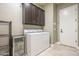 Laundry room with washer, dryer, and overhead cabinets at 14113 W Windsor Ave, Goodyear, AZ 85395