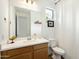 Clean bathroom, wood vanity, white toilet and shower at 16780 W Cameron Dr, Surprise, AZ 85388