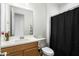 Bathroom with wood vanity, toilet and black shower curtain at 16780 W Cameron Dr, Surprise, AZ 85388