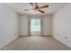 Bright bedroom with ceiling fan, window with curtains, and neutral carpet at 17251 N Del Webb Blvd, Sun City, AZ 85373