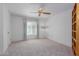 Bright bedroom with carpet, ceiling fan and built-in shelves at 17251 N Del Webb Blvd, Sun City, AZ 85373