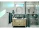 Modern bathroom with a floating vanity, walk-in shower, and dark-colored tile at 18145 W Rancho Dr, Litchfield Park, AZ 85340