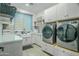 Bright laundry room, featuring modern washer, dryer, and ample cabinetry at 18145 W Rancho Dr, Litchfield Park, AZ 85340