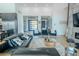 Modern living room with a black leather sectional and views to the kitchen and entry at 18145 W Rancho Dr, Litchfield Park, AZ 85340