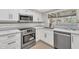 Modern kitchen with white cabinets, quartz countertops, and stainless steel appliances at 1819 W Evans Dr, Phoenix, AZ 85023