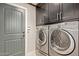 Bright laundry room with washer, dryer, and built-in cabinets at 19111 N 94Th Ave, Peoria, AZ 85382