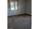 Spacious carpeted bedroom with large window and neutral walls at 20391 E Via Del Oro Dr, Queen Creek, AZ 85142