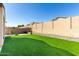 Expansive backyard featuring lush artificial grass, a built-in grill, and a privacy wall at 20496 W Valley View Dr, Buckeye, AZ 85396