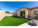 Large backyard featuring lush artificial grass, a built-in grill, and a privacy wall at 20496 W Valley View Dr, Buckeye, AZ 85396