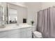 Neutral bathroom featuring a large mirror and tub with patterned shower curtain at 20496 W Valley View Dr, Buckeye, AZ 85396