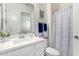 Bright bathroom featuring a white vanity, framed mirror, and tub with patterned shower curtain at 20496 W Valley View Dr, Buckeye, AZ 85396