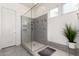 Modern bathroom featuring an upgraded frameless shower, neutral tiles, and bright natural light, and is move-in ready at 20496 W Valley View Dr, Buckeye, AZ 85396