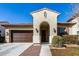 Inviting single-story home with an arched entryway, a brown garage door, and manicured front yard landscaping at 20496 W Valley View Dr, Buckeye, AZ 85396